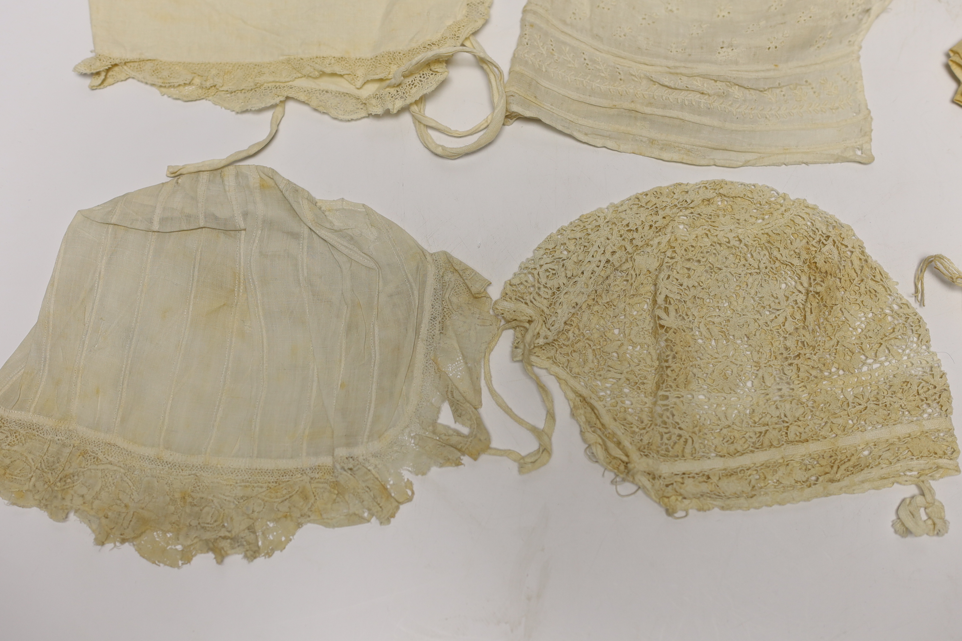 Seven baby bonnets, late 18th / 19th century, including a fine bobbin lace bonnet and unusual silk knitted and multi coloured floral designed beaded bonnet